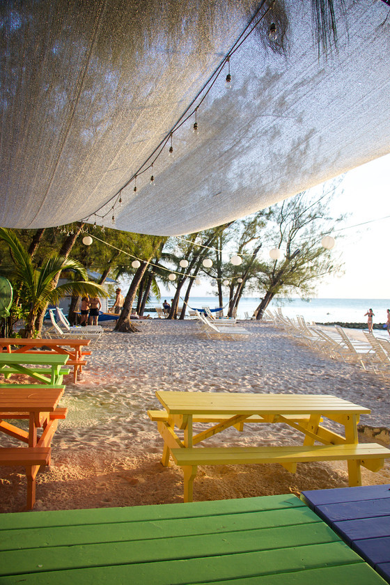 Rum-Point-Beach 
 Gentle sunset light at Rum Point Beach with colourful picnic tables 
 Keywords: Gentle, sunset, light, Rum Point Beach, colour, colourful, picnic table, peaceful, romantic